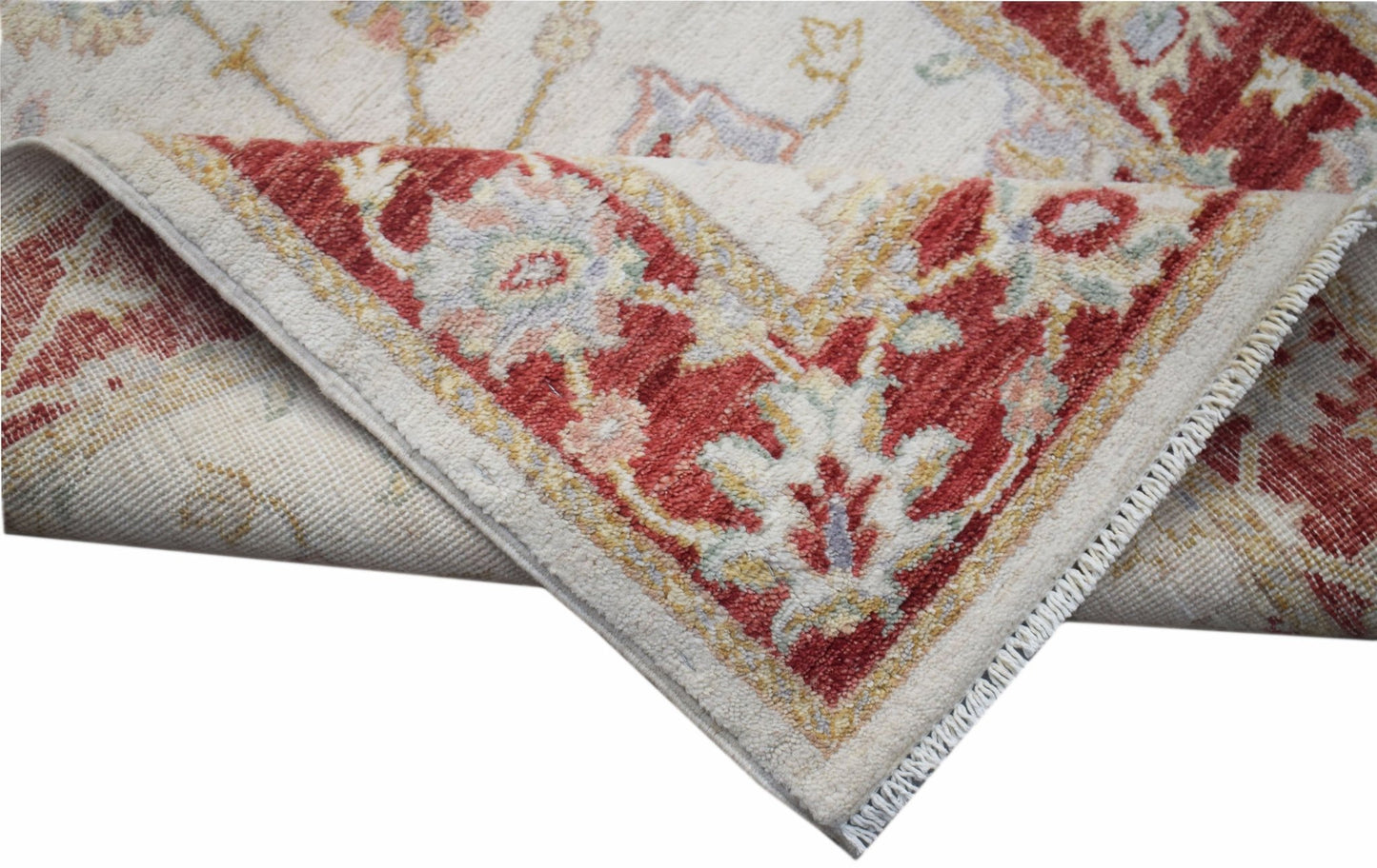 A handwoven Afghan Chobi rug featuring a traditional floral pattern in red and cream tones.