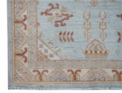 A handwoven Afghan Chobi rug featuring traditional floral motifs in soft blue and earthy tones.