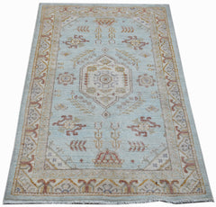 A rectangular Afghan Chobi rug featuring a central medallion on a light blue wool field.