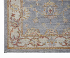 A handmade Afghan Chobi rug featuring a traditional floral pattern in soft blue and cream tones.