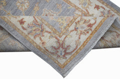 A handmade Afghan Chobi rug featuring a traditional floral pattern in soft blue and cream tones.