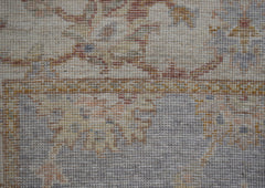 A close-up of a handwoven Afghan Chobi rug featuring a traditional floral pattern in earthy tones.