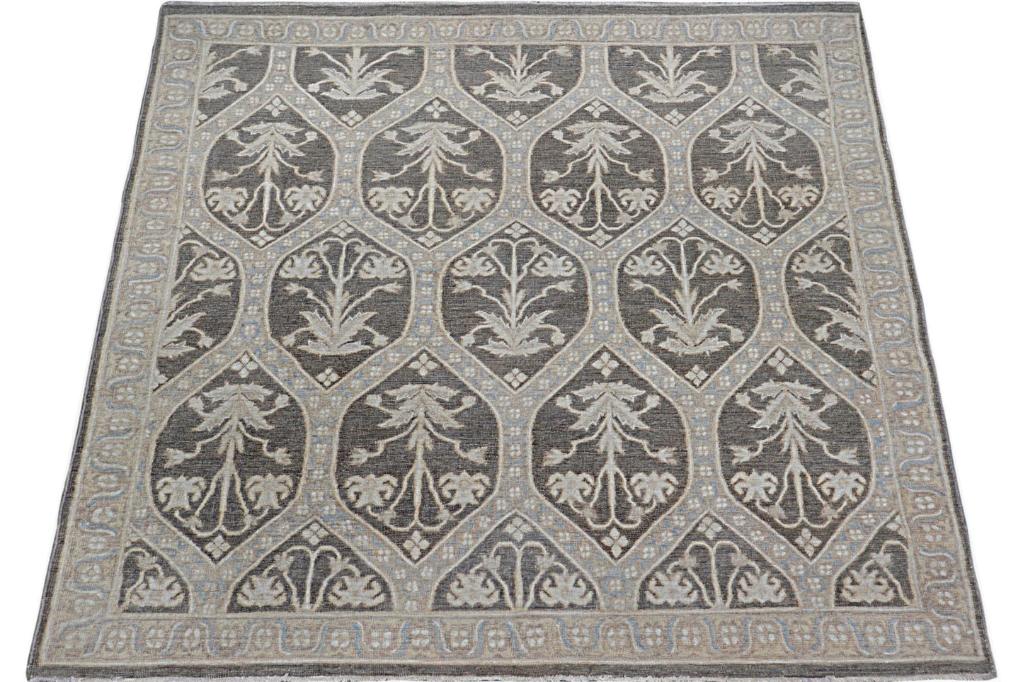 Handmade Afghan Chobi rug featuring a repeating floral motif in shades of brown and cream.