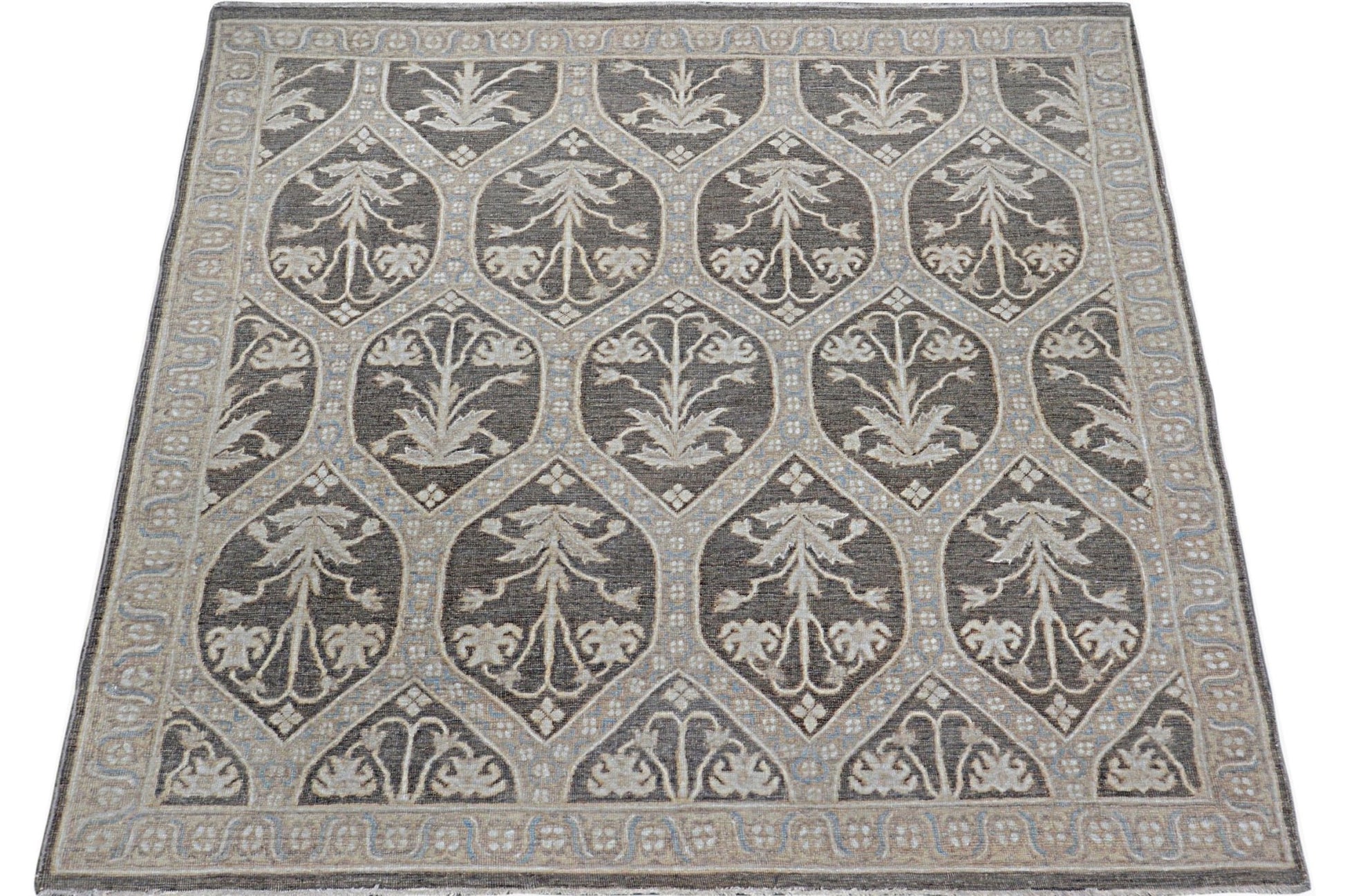 Handmade Afghan Chobi rug featuring a repeating floral motif in shades of brown and cream.