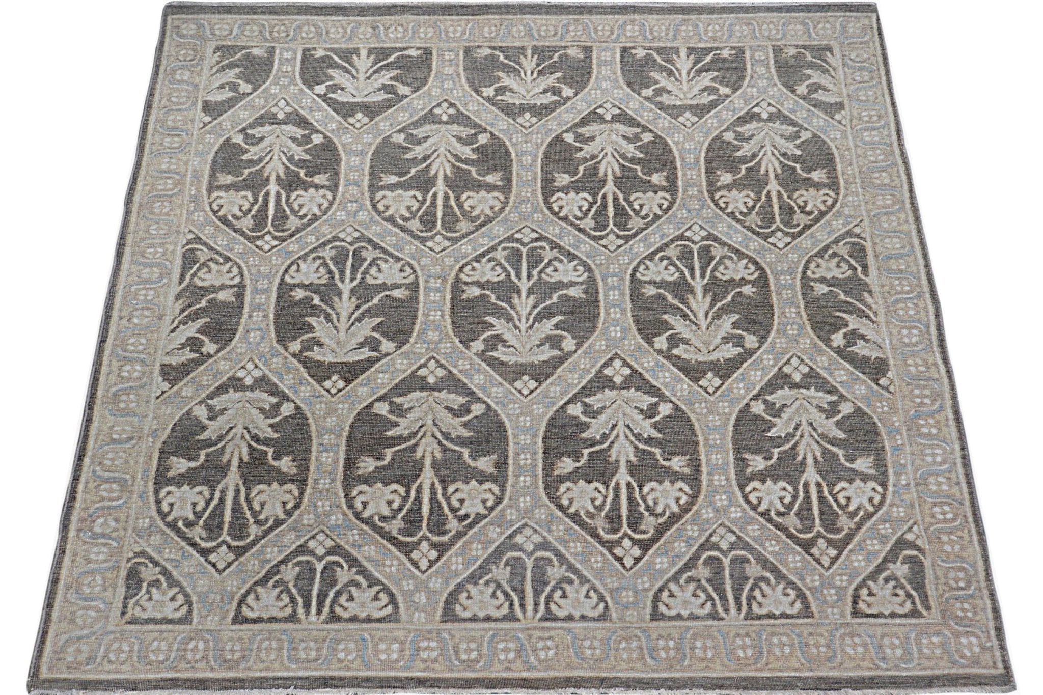 Handmade Afghan Chobi rug featuring a repeating floral motif in shades of brown and cream.