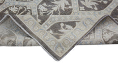 A corner of a handmade Afghan Chobi rug featuring a brown and beige floral pattern.