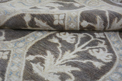 A handmade Afghan Chobi rug featuring a brown and cream floral pattern with a folded corner.