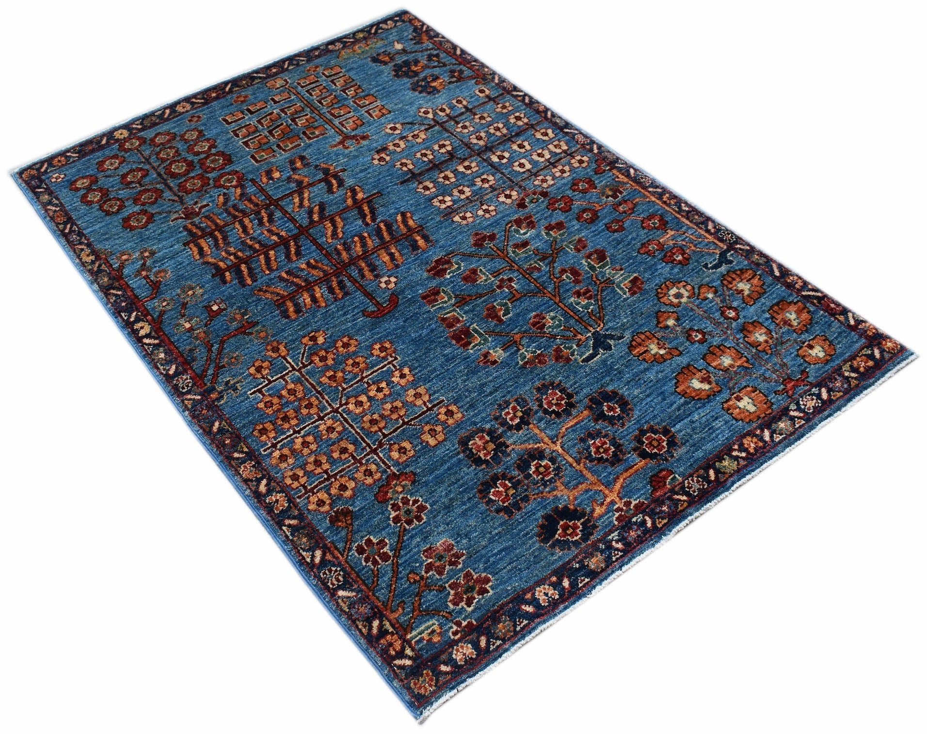 A rectangular Afghan Chobi rug featuring a blue field with stylized tree and floral motifs.