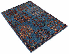 A rectangular Afghan Chobi rug featuring a blue field with stylized tree and floral motifs.