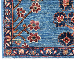 A handwoven Afghan Chobi rug featuring a blue field with floral patterns and a decorative border.