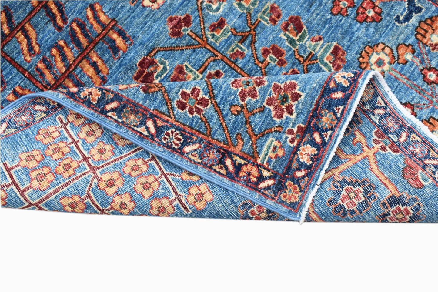 A handwoven Afghan Chobi rug featuring a blue field with traditional floral patterns.