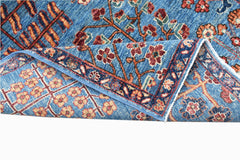 A handwoven Afghan Chobi rug featuring a blue field with traditional floral patterns.