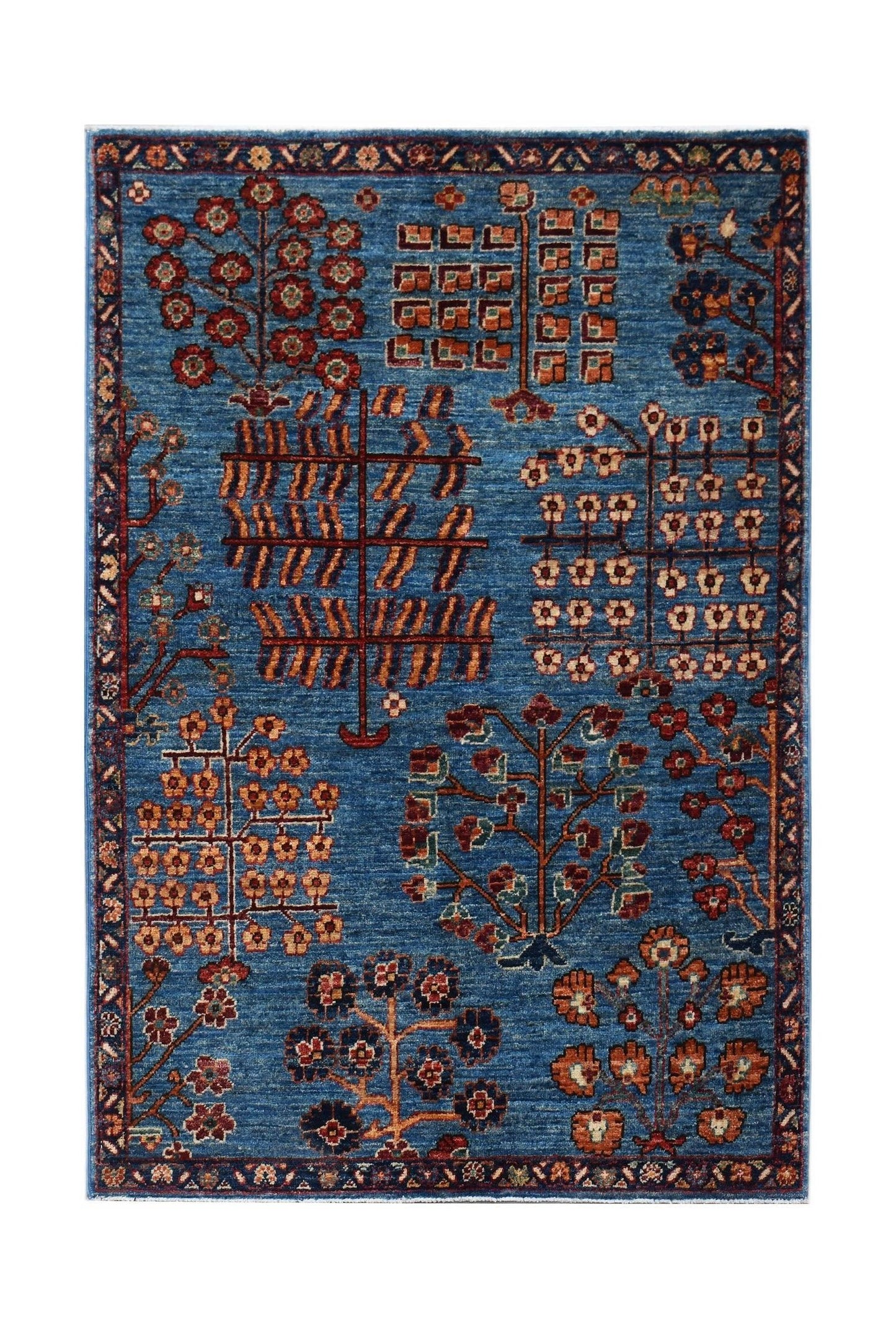 A rectangular Afghan Chobi rug featuring a blue field with stylized tree and floral motifs.