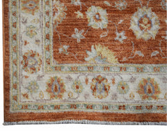 A handmade Afghan Chobi rug featuring a floral pattern in rust, cream, and soft blue tones.