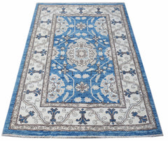 A rectangular Afghan Chobi rug featuring a blue and cream floral pattern with a decorative border.