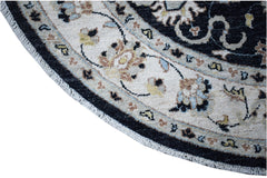 A round, handwoven Afghan Chobi rug featuring intricate floral patterns in a cream and black border.