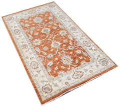 A rectangular Afghan Chobi rug featuring a floral pattern in orange, cream, and grey tones.