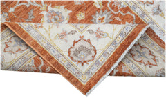 A folded Afghan Chobi rug featuring a traditional floral pattern in rust orange and cream tones.