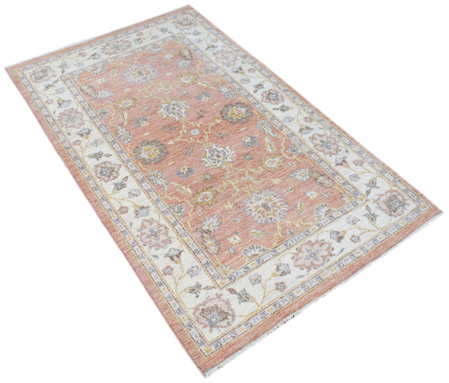 A rectangular Afghan Chobi rug featuring a traditional floral pattern in soft peach and cream tones.