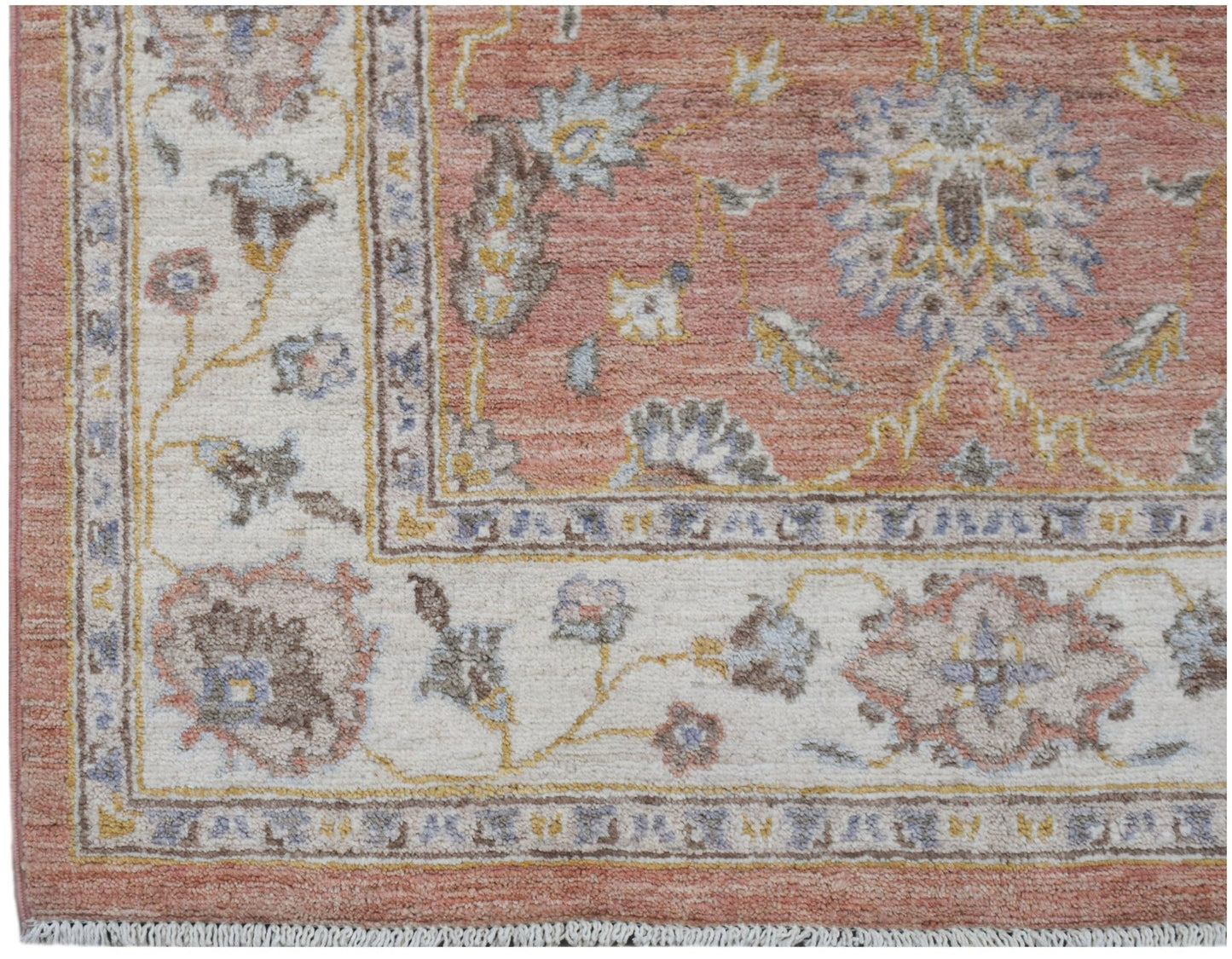 Afghan Chobi rug with a floral pattern in muted red and cream.
