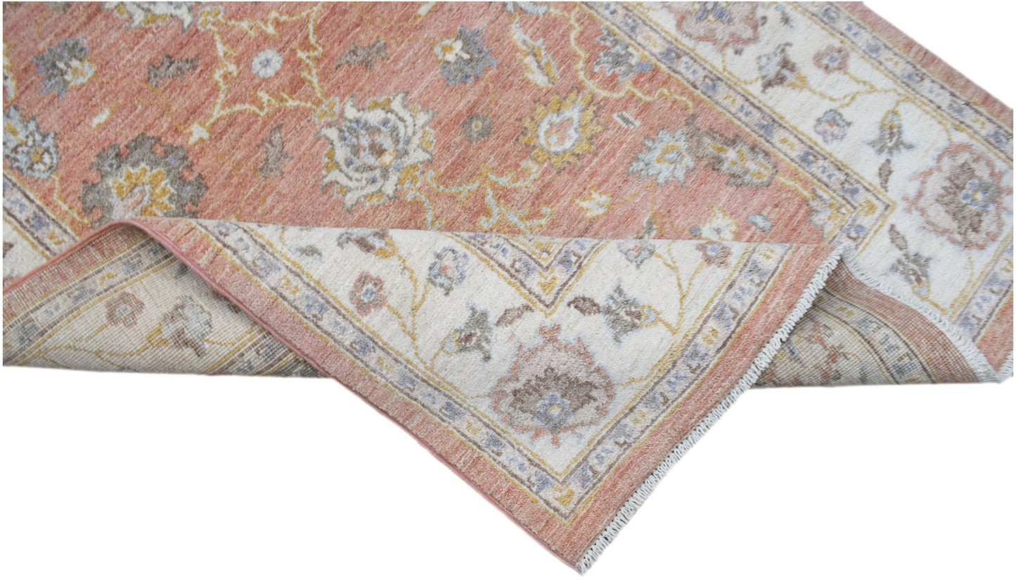 A handmade Afghan Chobi rug featuring a traditional floral pattern in soft terracotta and cream.