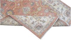 A handmade Afghan Chobi rug featuring a traditional floral pattern in soft terracotta and cream.