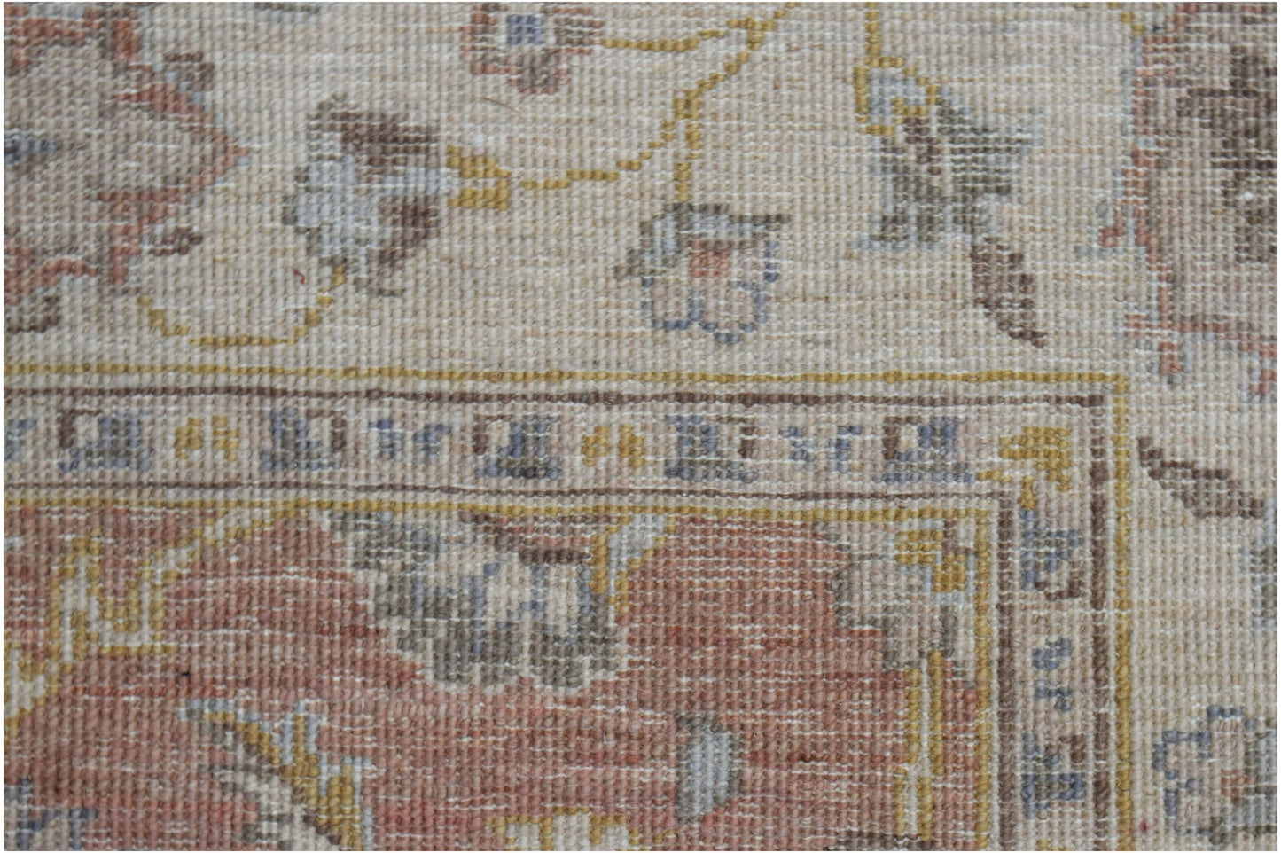 A close-up of a handwoven Afghan Chobi rug featuring traditional floral patterns in earthy tones.