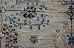 A handwoven Afghan Chobi rug featuring intricate blue and brown floral patterns on a beige field.