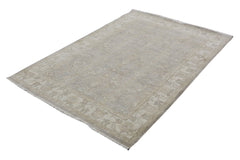 A handmade Afghan Chobi rug featuring a traditional floral pattern in neutral beige tones.