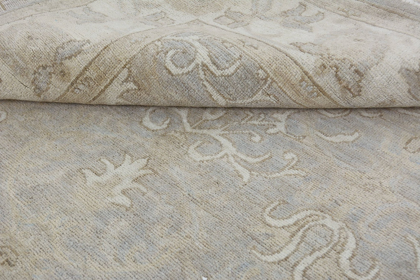 A handmade Afghan Chobi rug featuring a neutral, wood-toned floral pattern in handspun wool.