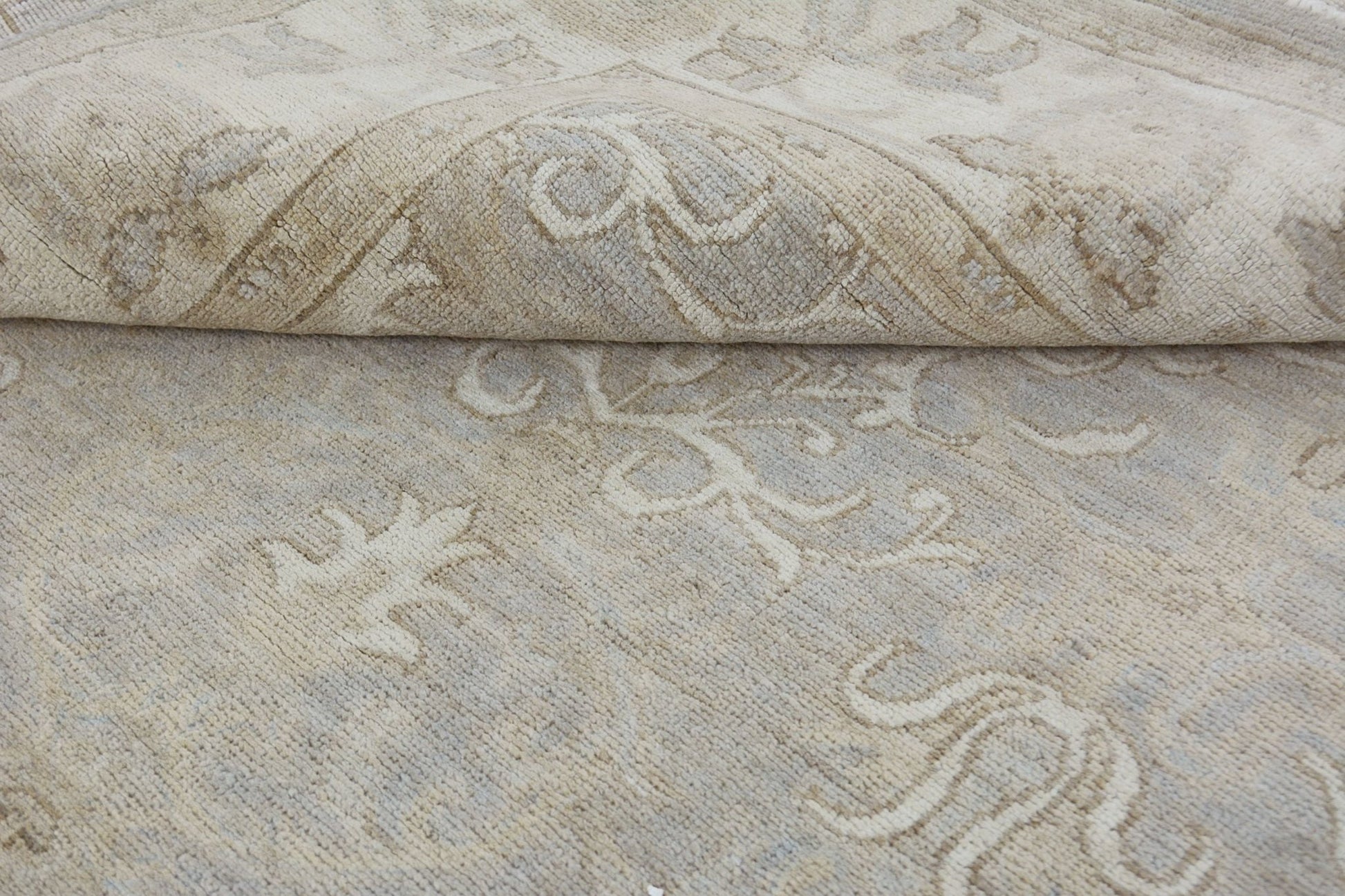 A handmade Afghan Chobi rug featuring a neutral, wood-toned floral pattern in handspun wool.
