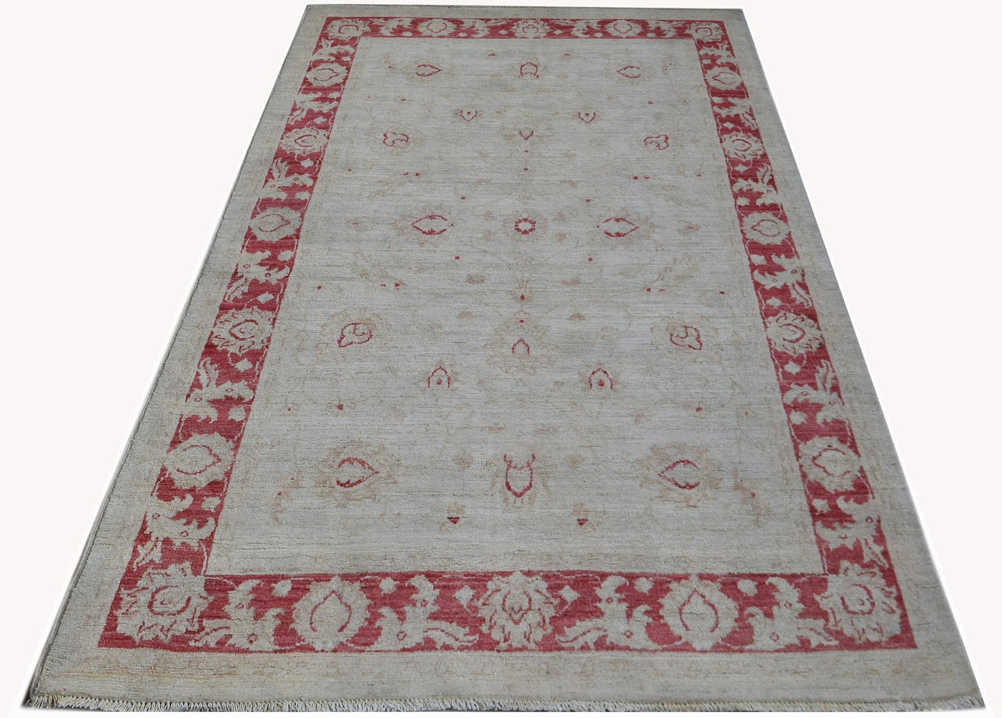 An Afghan Chobi rug featuring a cream field with red floral motifs and a matching red border.
