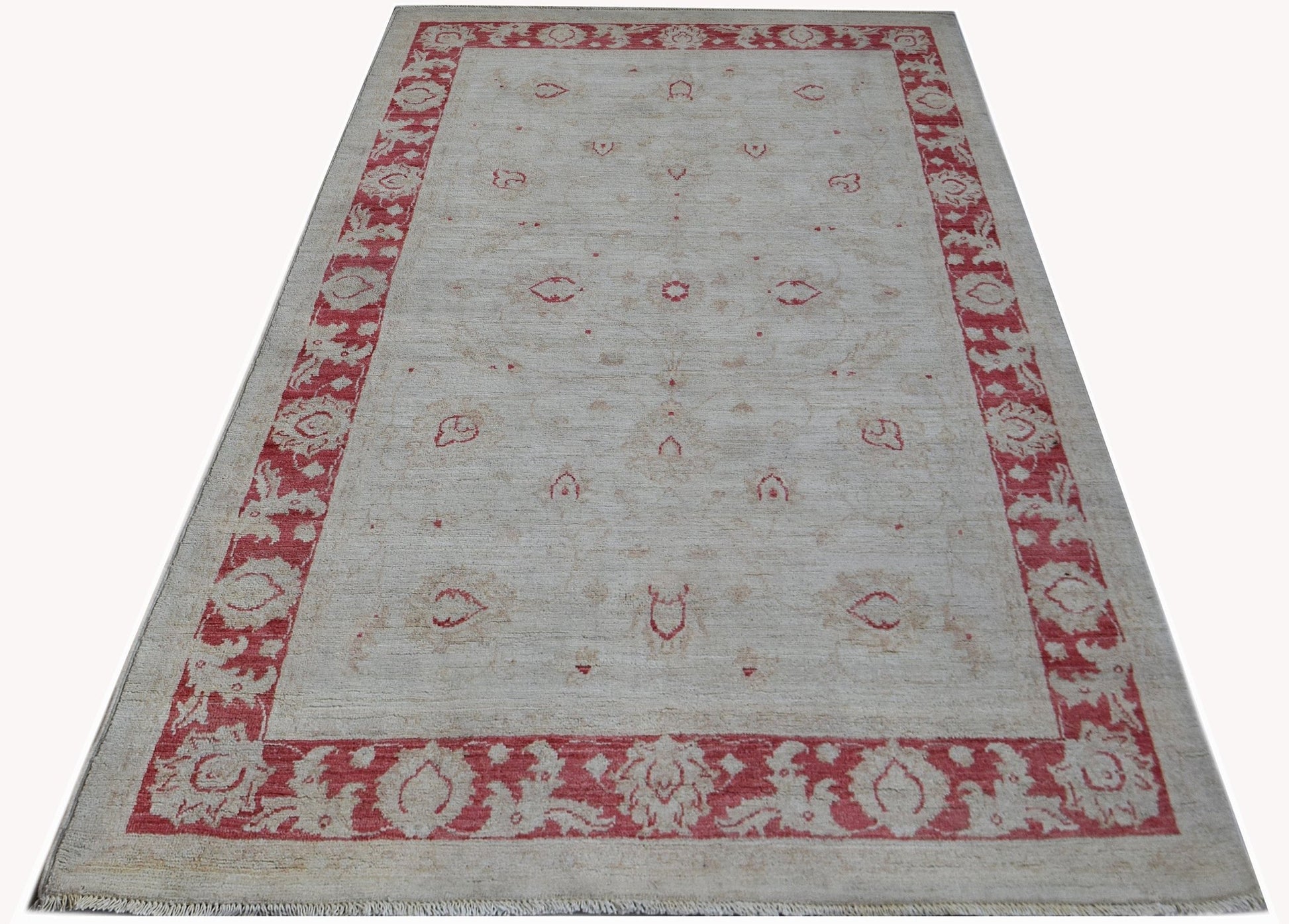 An Afghan Chobi rug featuring a cream field with red floral motifs and a matching red border.
