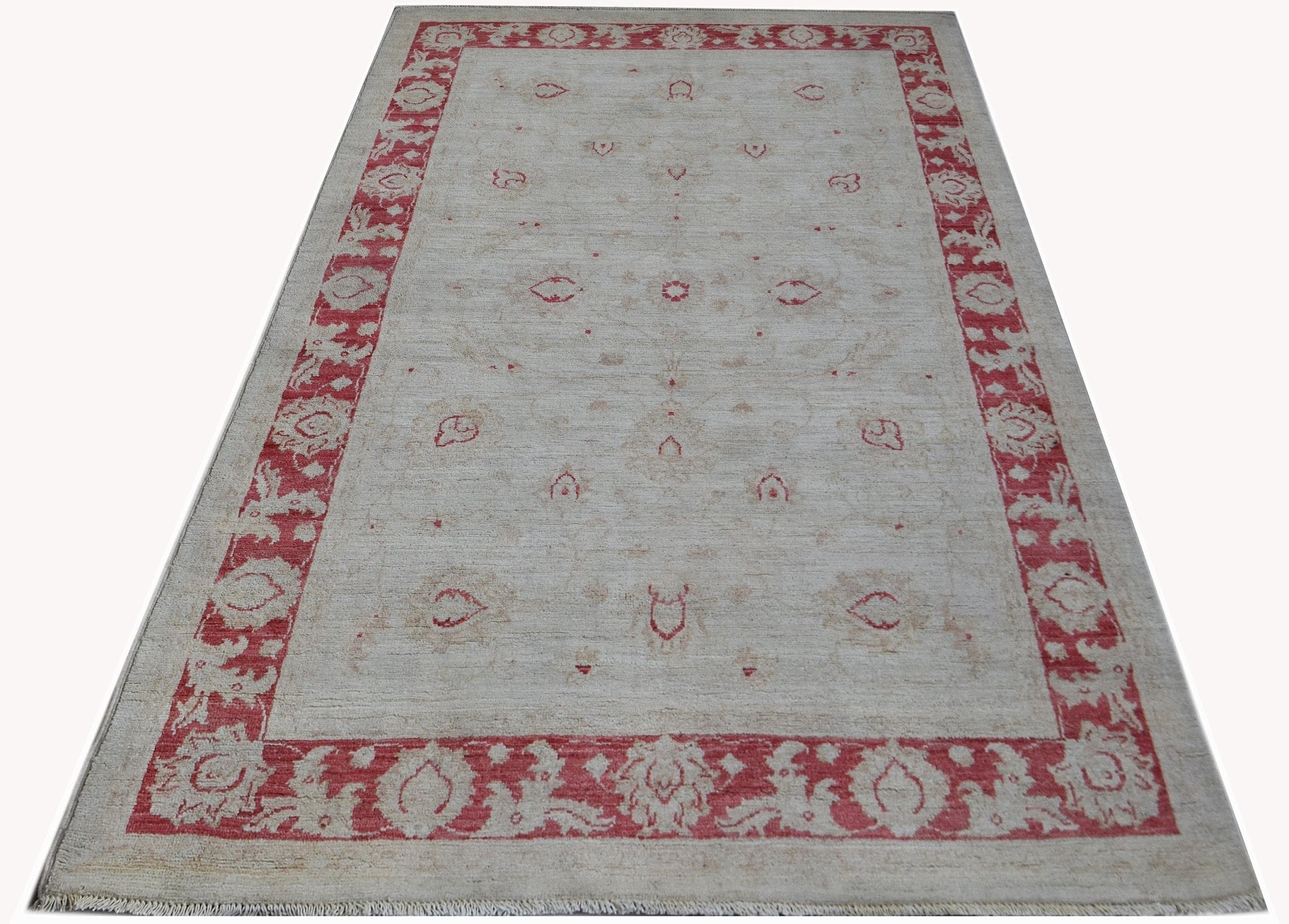 An Afghan Chobi rug featuring a cream field with red floral motifs and a matching red border.