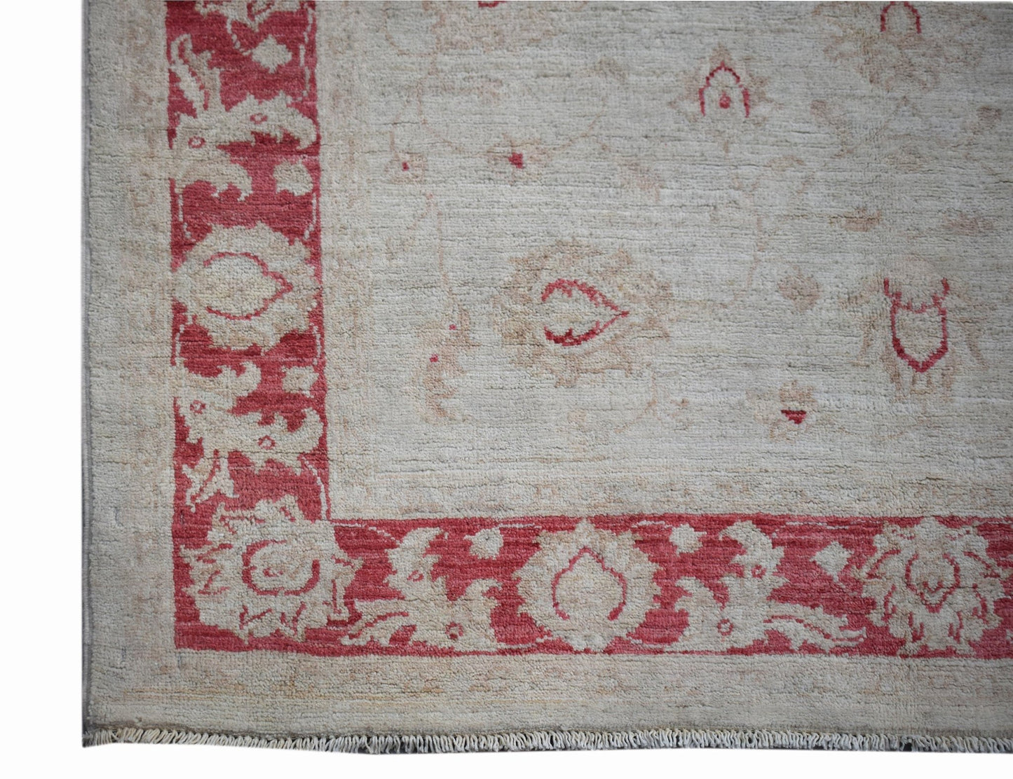 A handmade Afghan Chobi rug featuring a red floral border on a light beige wool field.
