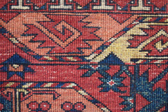 A close-up of a handwoven Afghan Chobi rug featuring traditional geometric patterns in warm tones.