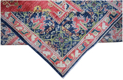 A handwoven Afghan Chobi rug featuring a traditional floral pattern in red, blue, and green tones.