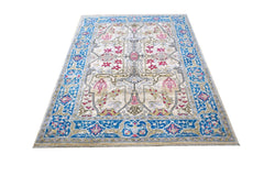 An Afghan Chobi rug featuring a traditional floral pattern in blue, pink, and beige tones.