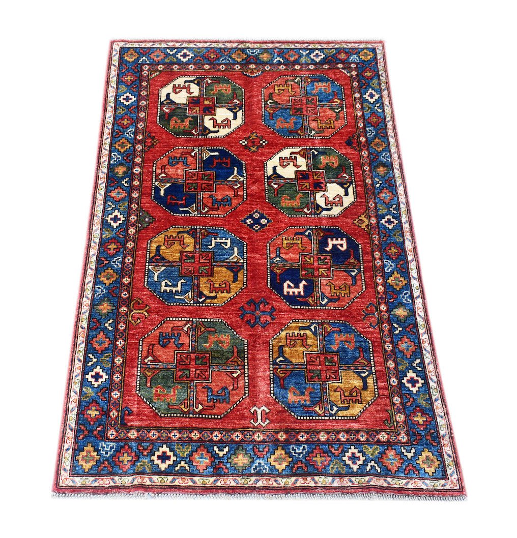 Handmade Afghan Chobi rug featuring a red field with eight geometric octagonal medallions.