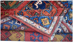 A handwoven Afghan Chobi rug featuring a geometric pattern in vibrant red, blue, and yellow tones.
