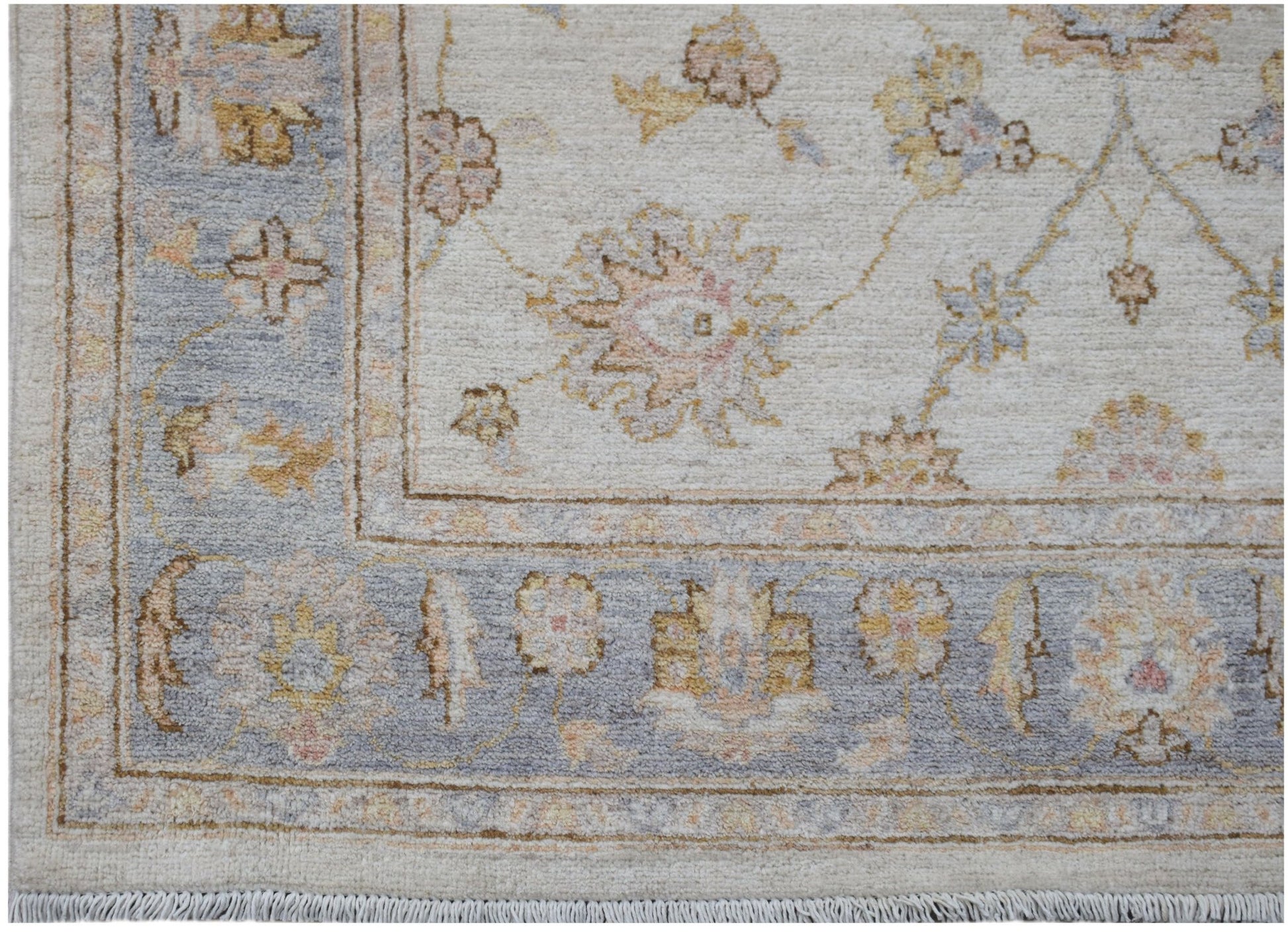 A handmade Afghan Chobi rug featuring a floral pattern in soft blue and cream tones.