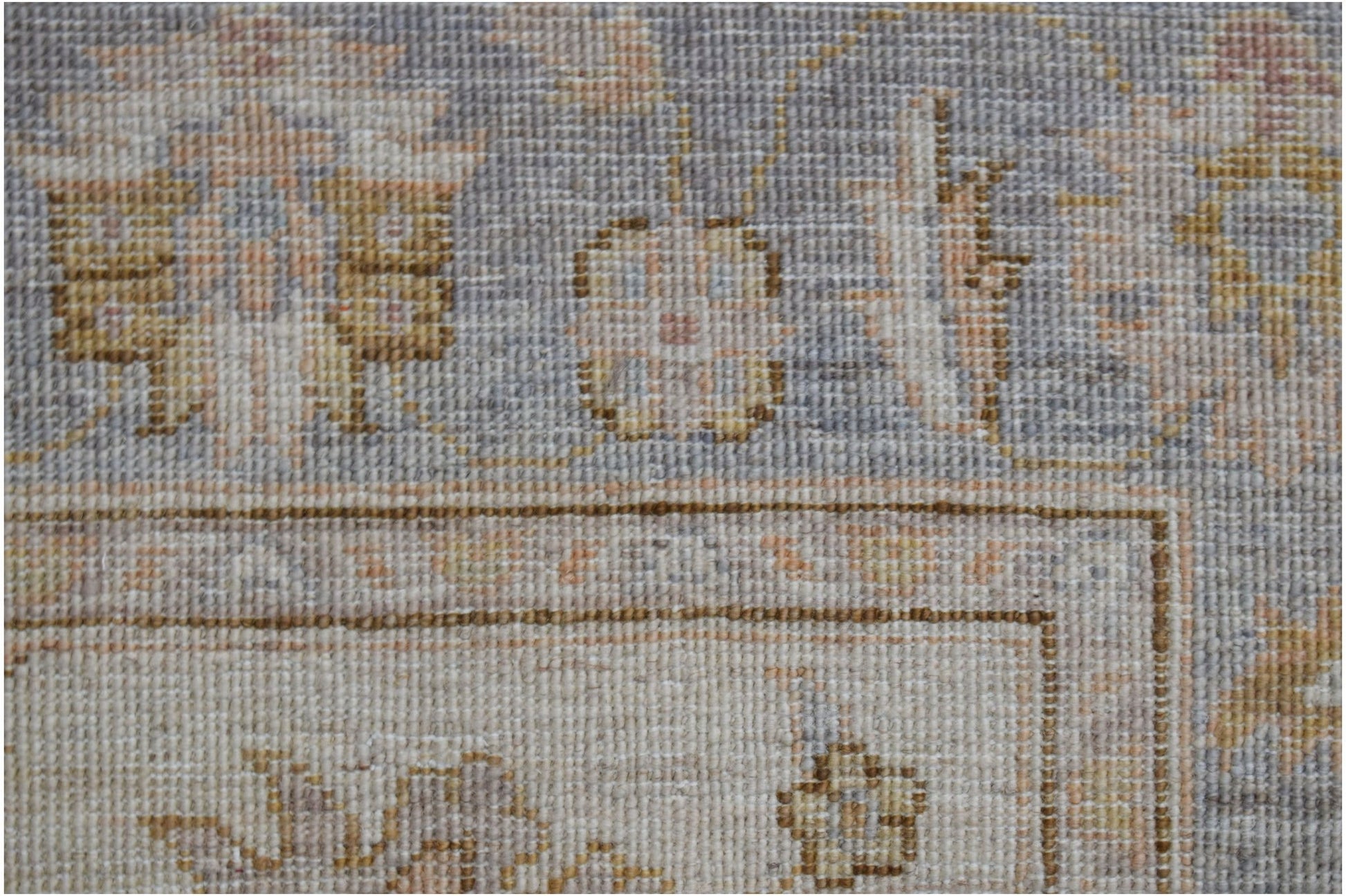 A close-up of a handwoven Afghan Chobi rug featuring traditional floral patterns in muted tones.