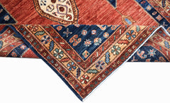 A handwoven Afghan Chobi rug featuring a folded corner with intricate geometric and floral patterns.