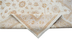 A handwoven Afghan Chobi rug featuring a cream background with soft gold floral patterns.