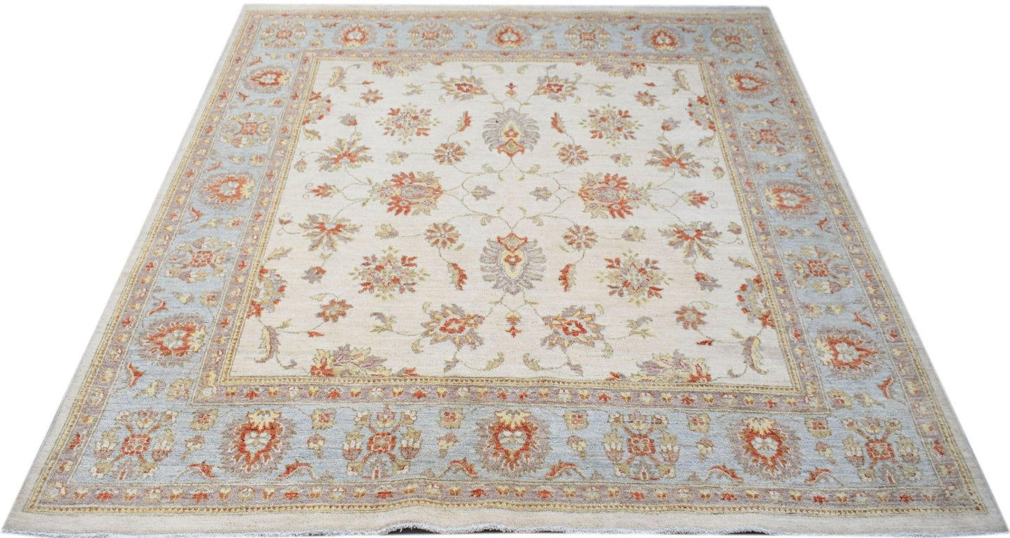 A handmade Afghan Chobi rug featuring a floral pattern in soft orange and blue on a cream field.