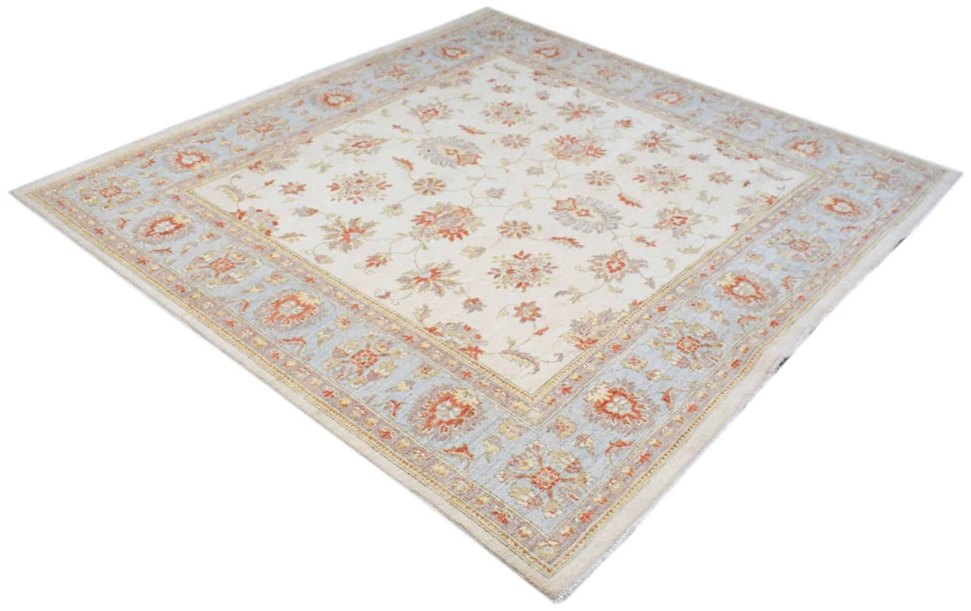A square Afghan Chobi rug featuring a floral pattern in soft orange and blue on a cream background.