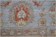 A close-up of a handwoven Afghan Chobi rug featuring traditional floral motifs in earthy tones.