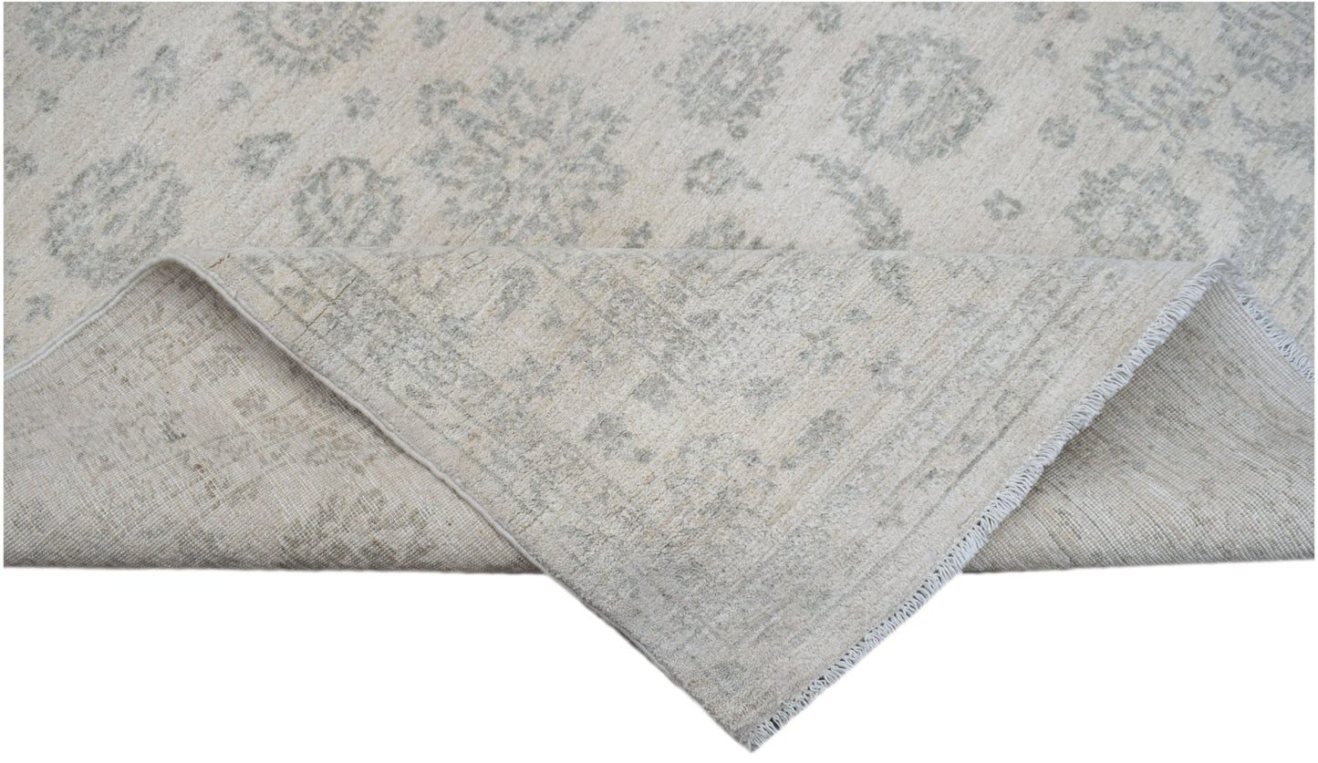 A handwoven Afghan Chobi rug featuring a traditional floral pattern in soft beige and grey tones.