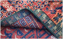 A handwoven Afghan Chobi rug featuring traditional geometric patterns in red, blue, and green.