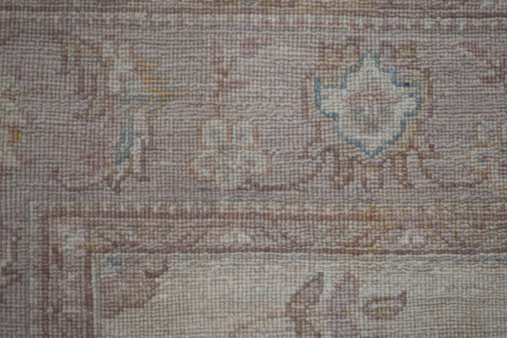 A close-up of a handwoven Afghan Chobi rug featuring traditional floral patterns in muted tones.